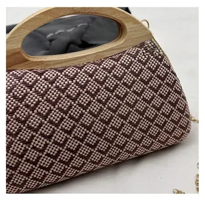 Detailed view of woven straw bag texture with elegant round wooden handle and gold chain