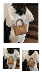 Detail of a brown lychee pattern leather handbag with gold metal clasp and shoulder strap