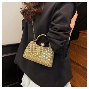 Close-up of golden rhinestone evening bag with pearl buckle and elegant metal handle