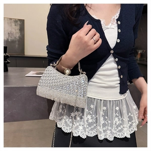 Detail of silver rhinestone evening bag with pearl clasp and metal handle strap