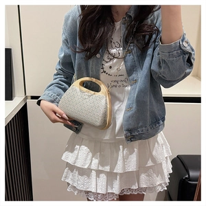 Detail of hand-woven straw crossbody bag with circular wooden handle and gold chain