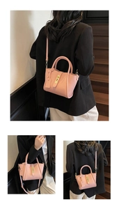 Detail view of pink leather handbag showing litchi grain texture and metal buckle