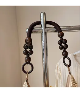 Detail of wooden bead handle and woven texture on a French style straw beach bag