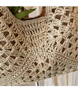 Detailed view of beige hollow crochet texture and fabric lining of this woven beach bag