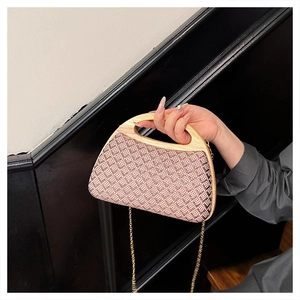 Detail of bohemian geometric woven clutch with natural wooden handle and gold chain