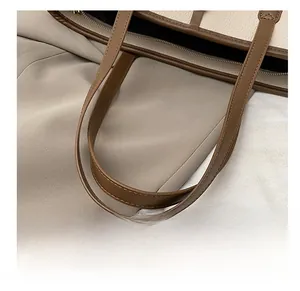 Detail of lychee pattern leather tote bag showing sturdy handles and zip closure