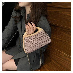 Detail of retro woven handbag featuring a semicircular wooden handle and gold chain strap