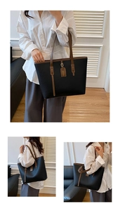 Detail of black large capacity tote bag with brown handles and lychee grain texture