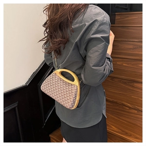 Detail of vintage plaid straw handbag featuring a semi-circular wooden handle and gold chain