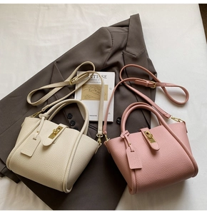 Detail of minimalist cream and pink leather bags with gold twist locks and adjustable straps