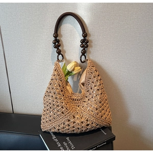 Detailed shot of hollow straw weave pattern with dark wooden beads on handle