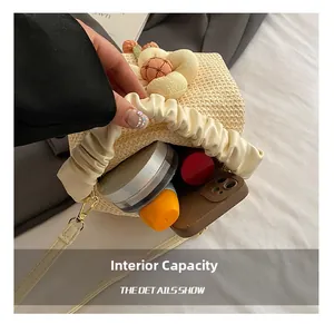 Detail showing internal capacity of the beige straw handbag for phone and cosmetics