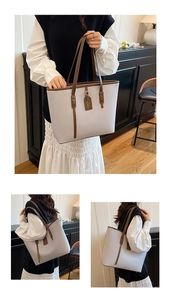 Detail view of large tote bag with gray faux leather texture and brown handle accents