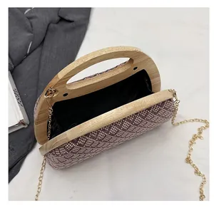 Macro view of woven clutch interior with wooden handle and gold chain strap