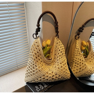 Detail of beige hollow-out woven tote with vintage brown wooden bead handle and lining