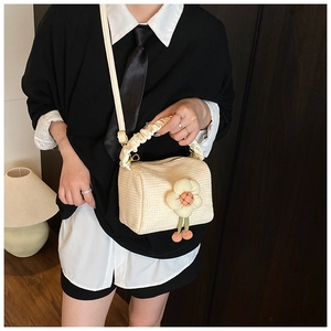 Detail of cream woven handbag with 3D fabric flower charm and ruched cloud handle