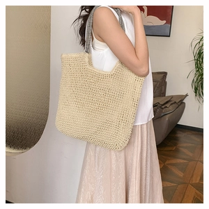 Detail of hand-woven tote bag with black and white striped straps for daily casual style