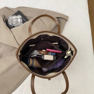 Internal view of brown leather tote bag with compartments holding daily essentials