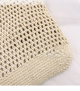 Close-up of cream woven shoulder bag showing intricate hollow crochet texture and seams