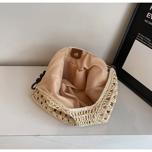 Detailed interior of woven straw bag with sateen lining, inner pocket and bead handle