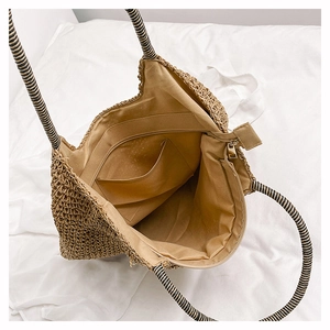 Detail view of woven bag showing inner lining, zipper closure and striped rope handles