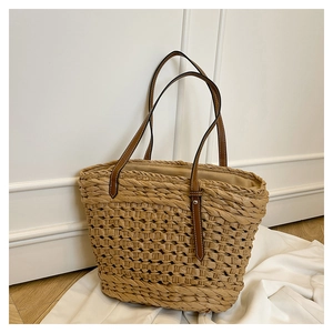 Gros plan sur la texture du sac en paille tissé main avec bandoulière en cuir brun