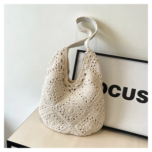 Detail of beige crochet hobo bag with classic grandmother square floral woven pattern