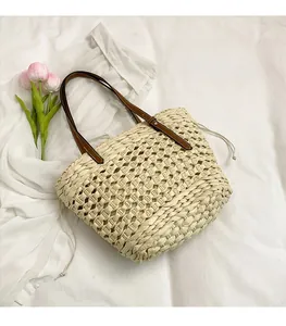 Détail du sac cabas en paille avec anses en cuir marron et doublure à cordon