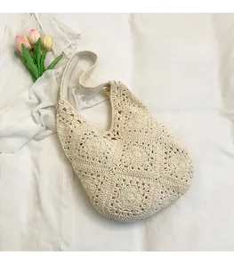 Close-up of cream handmade crochet tote bag with intricate floral knit pattern and tulip decor