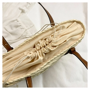 Vue de dessus d'un sac panier en paille avec doublure et anses en cuir marron