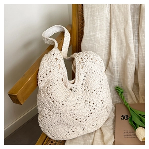 Detailed macro view of cream woven shoulder bag with intricate hollow crochet pattern