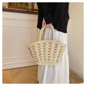 Detail of handmade straw bag featuring cream and brown geometric weaving patterns