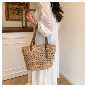 Détail du sac cabas en paille tissé main avec anses en cuir marron et maille évidée