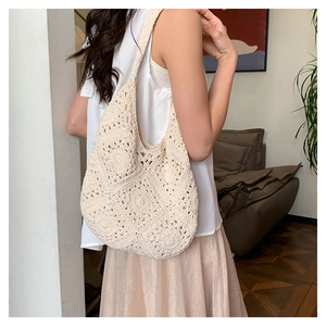 Close-up of a handmade bohemian woven tote bag in cream white with intricate crochet details