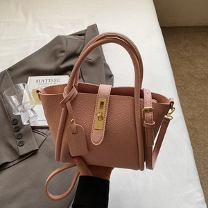 Elegant pink lychee leather tote bag with gold twist lock and adjustable shoulder strap