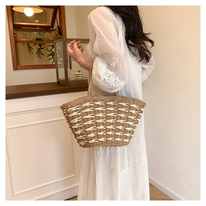 Close-up of a woven straw bucket bag with dual handles for a summer vacation look
