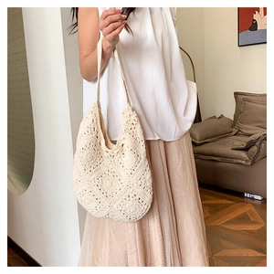 Detail of crochet hollow pattern on a cream woven shoulder bag for a bohemian summer look