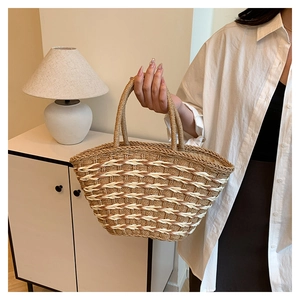 Detail of woven straw tote bag with brown and beige wavy patterns for summer styling