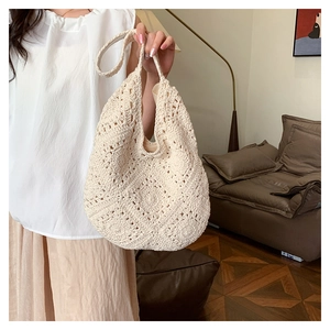 Detail of cream crochet woven handbag with retro geometric cut-out patterns and soft texture