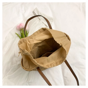 Vue de dessus du grand sac en paille avec doublure à cordon et anses en cuir marron