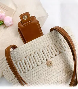 Close-up of woven bucket bag with brown leather strap and high-quality gold magnetic clasp