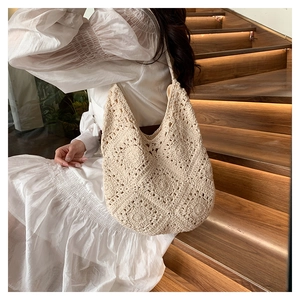 Chic cream woven crochet shoulder bag shown in a lifestyle setting with a soft hobo silhouette