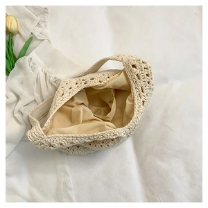 Detail view of cream crochet woven bag with cotton knit pattern and smooth fabric lining
