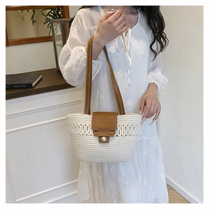 Detail of hand-woven tote bag with large pearl buckle and premium brown leather straps