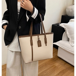 Large capacity tote bag with beige lychee leather and brown trim in cozy home setting