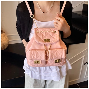 Detail view of pink quilted leather backpack with gold chain straps and twist locks