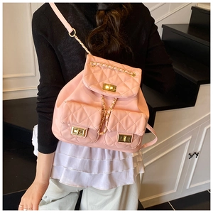 Close-up of pink quilted backpack featuring gold-tone chain straps and turn-lock pockets
