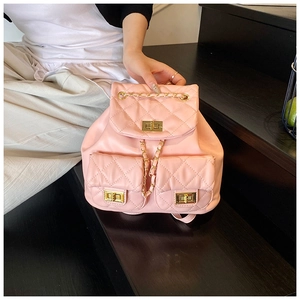 Detailed view of pink quilted leather backpack with gold metal twist locks and chain