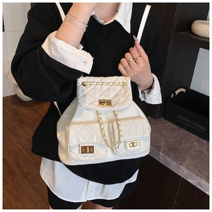 Close-up of quilted white PU leather backpack with gold chain straps and metal twist lock