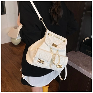 Rear view of model wearing white quilted backpack with gold chain straps and turn-lock
